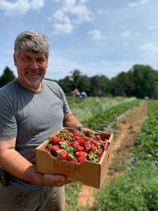 Man holding a flat of strawberries