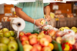 Person putting apples in a bag