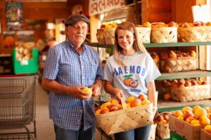 Jaemor Farms interior image with people holding basket of peaches