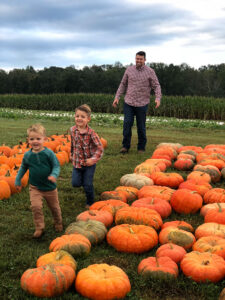 Family running through pumpkin patch at Jaemor Farms