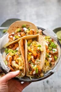 Four peach tacos arranged on a gray plate