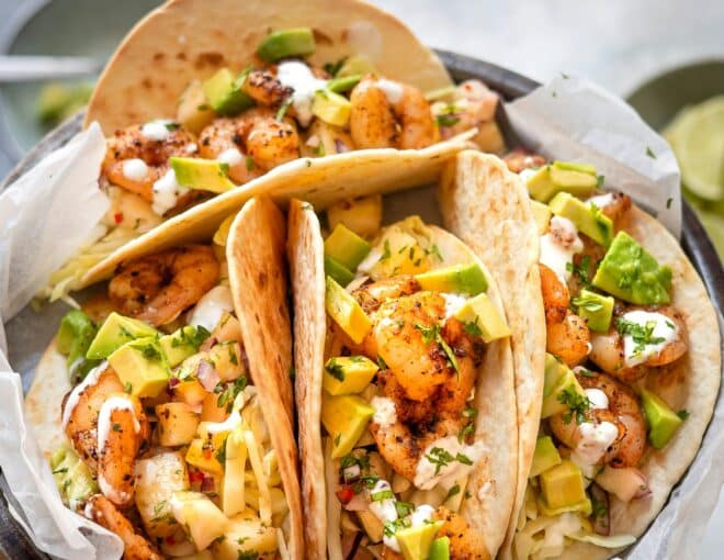 Four peach tacos arranged on a gray plate