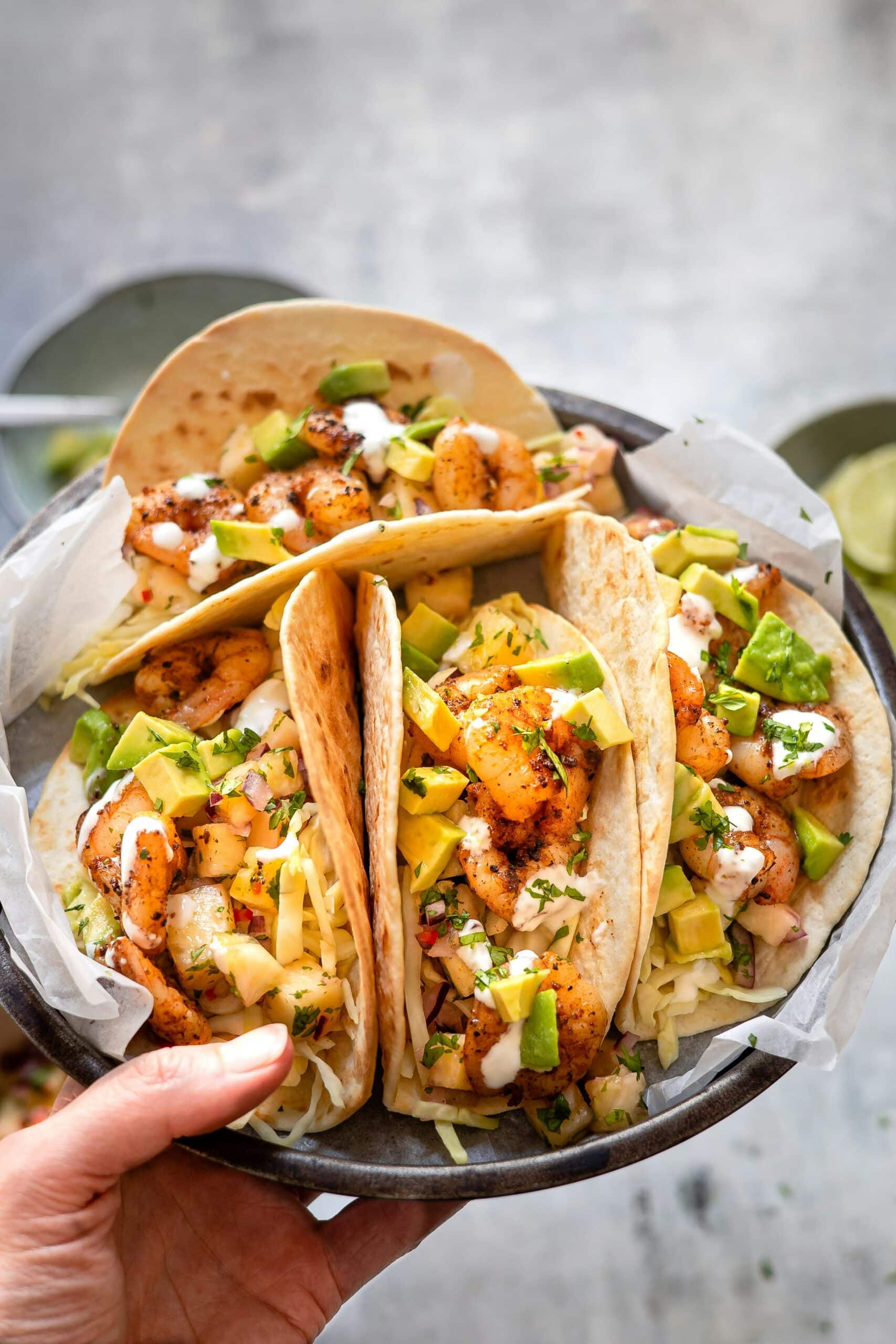 Four peach tacos arranged on a gray plate